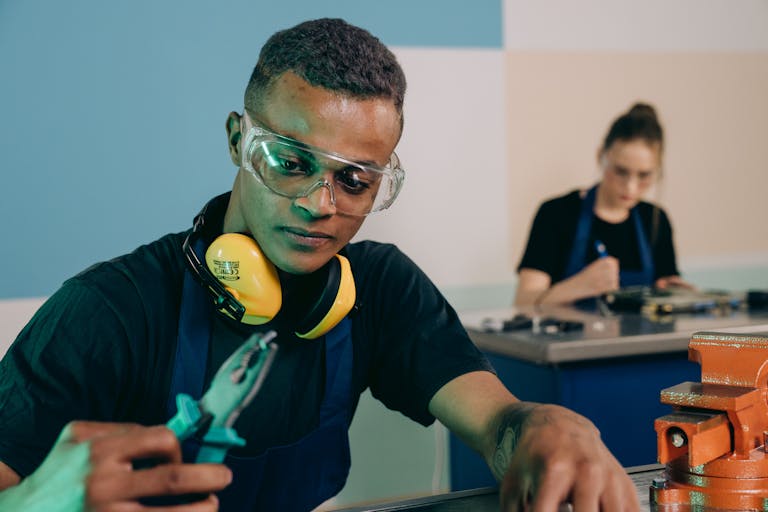 Two technicians carefully working with tools in a modern workshop.